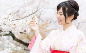 A Japanese woman wearing kimono looking cherry blossoms = Shutterstock