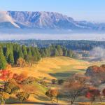 Beautiful pictures of mountains and mist,Pine trees and trees change color Including a golf course in the morning at Aso,Kumamoto prefecture,Japan = Shutterstock