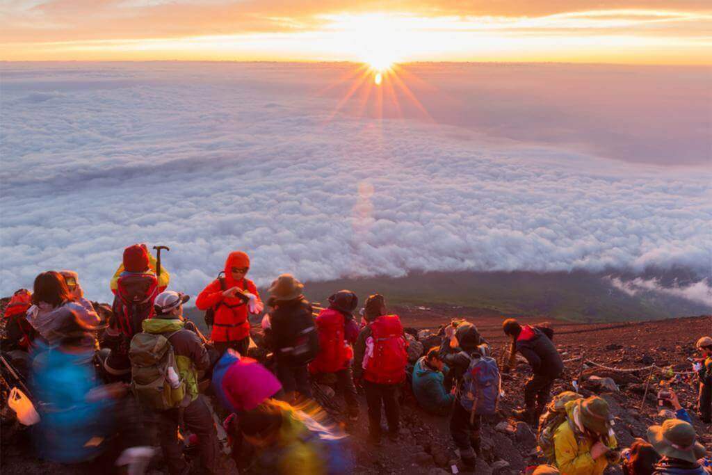 Crowds of climbers at the summit of Mt. Fuji. Most Japanese climb the mountain at night in order to be in a position at or near the summit when the sun rises = Shutterstock