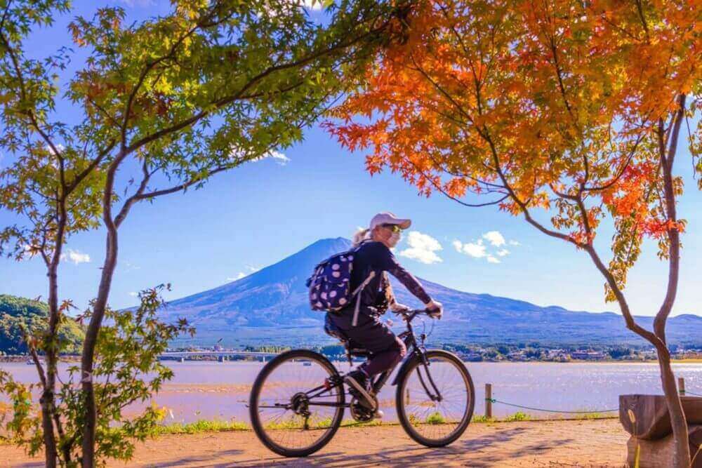 Cycling around Kawaguchiko lake with mountain Fuji in background = Shutterstock