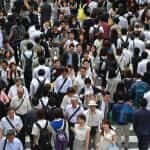 People cross the street in front of Osaka train station in Osaka, Japan = Shutterstock
