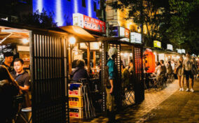 People eating Yatai mobile food stall at night in Fukuoka, Kyushu, Japan = Shutterstock