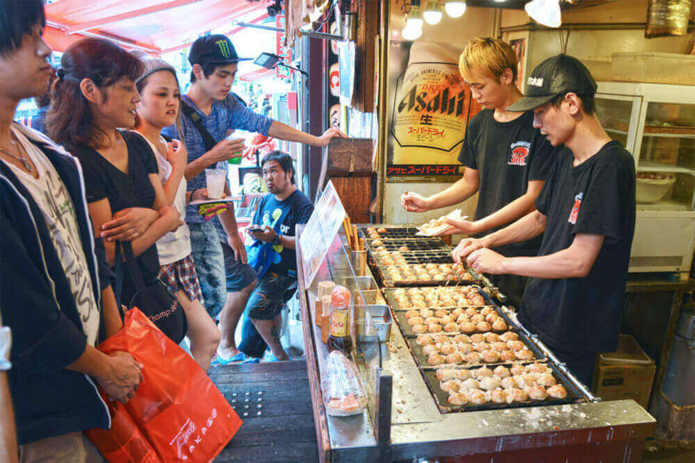 Takoyaki (a ball-shaped Japanese snack) shop always has a long customer queue = Shutterstock