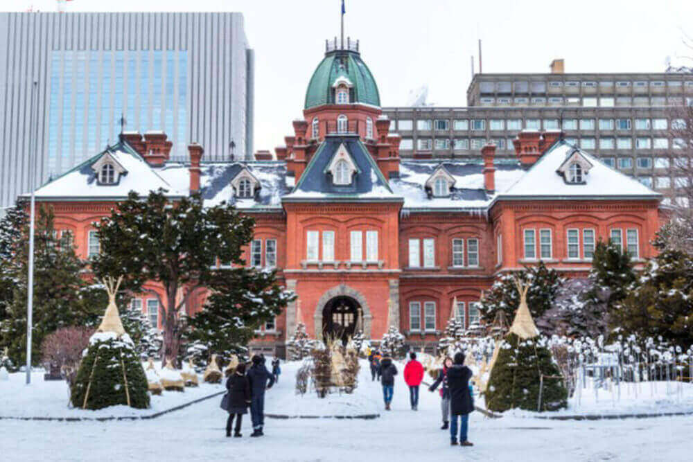 The red brick former Hokkaido Government office is popular tourist destination. Featured here day scene of the attraction during winter with snow = Shutterstock