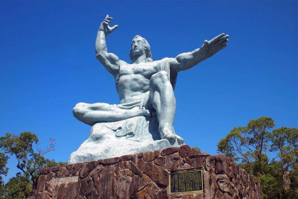 View of Nagasaki Peace Monument at Nagasaki Peace Park. Peace statue created by sculptor Seibou Kitamura of Nagasaki Prefecture = Shutterstock