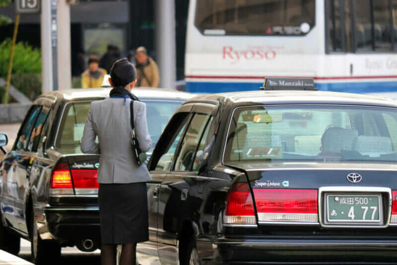 Japanese lady waiting for call taxi in Narita International Airport = shutterstock