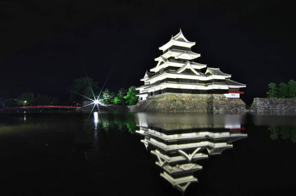 Bautiful reflection in water at night of Matsumoto Castle. It is a Japanese premier historic castles in easthern Honshu, Matsumoto-shi, Chubu region, Nagano Prefecture, Japan = shutterstock