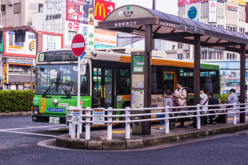 A bus waits at a bus stop at the station in Tokyo = shutterstock
