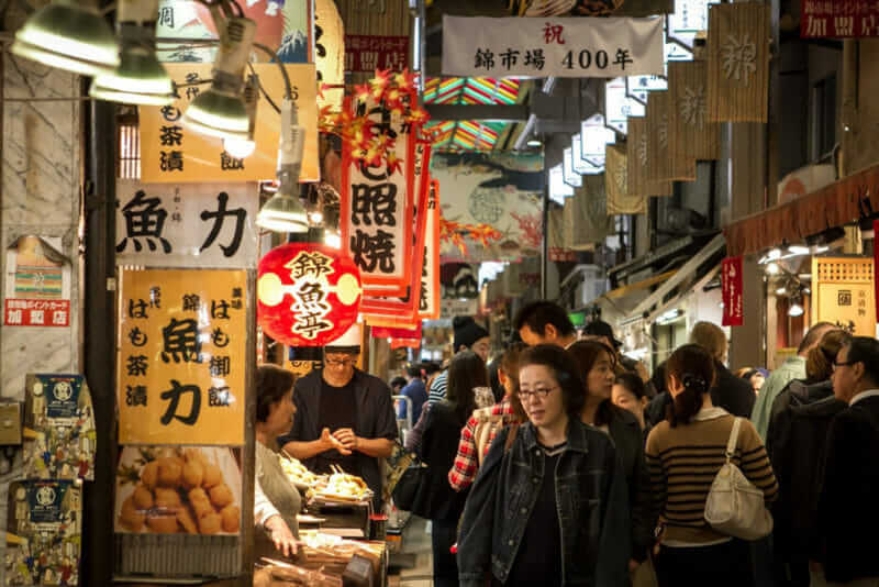 People and tourists flocked into the famous Nishiki Market in Kyoto, Japan = shutterstock