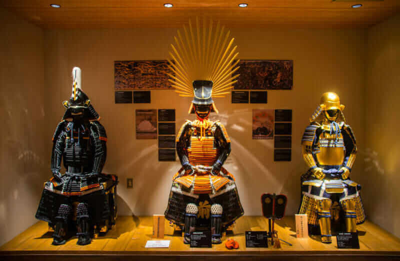 Many Samurai costumes are shown in exhibition hall inside the Samurai museum at Shinjuku = shutterstock