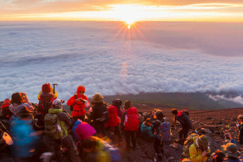 Crowds of climbers at the summit. Most Japanese climb the Fuji mountain at night in order to be in a position at or near the summit when the sun rises = shutterstock