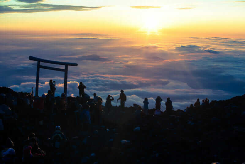 Hikers at the summit of Mt. Fuji during sunrise = shutterstock