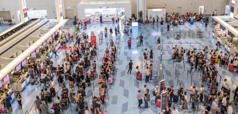 Passengers queuing and checking in at airlines counter at Haneda International Airport = shutterstock