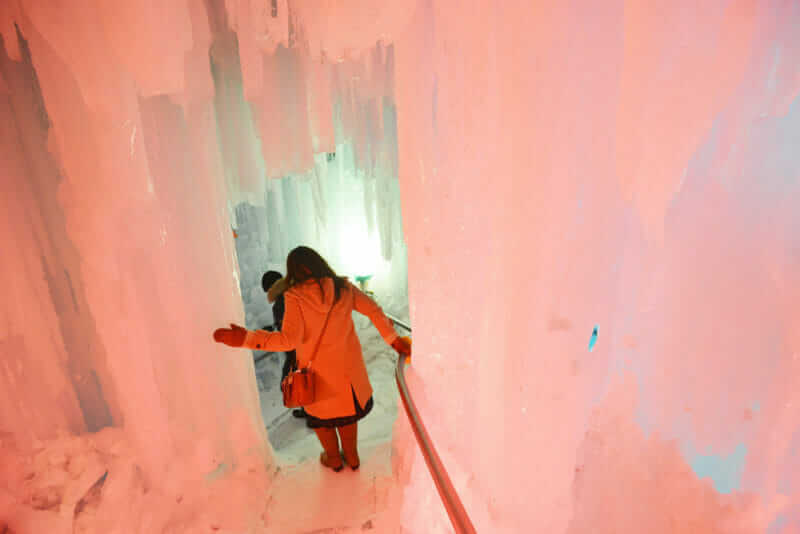 Way down in the Ice cave Illuminated icicle with tourist at Sapporo Snow Festival, Hokkaido, japan = shutterstock_729045385