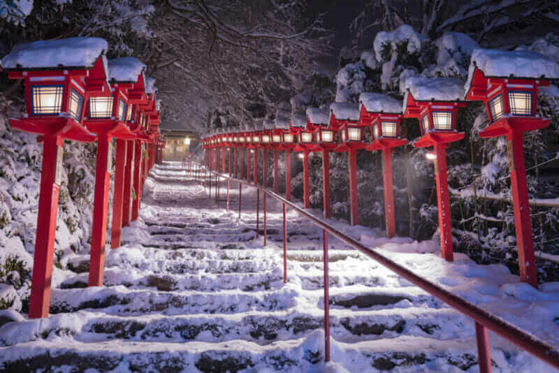 Stone stair and traditional light pole with snow fall in winter at Kifune shrine , Kyoto prefecture , Japan = shutterstock