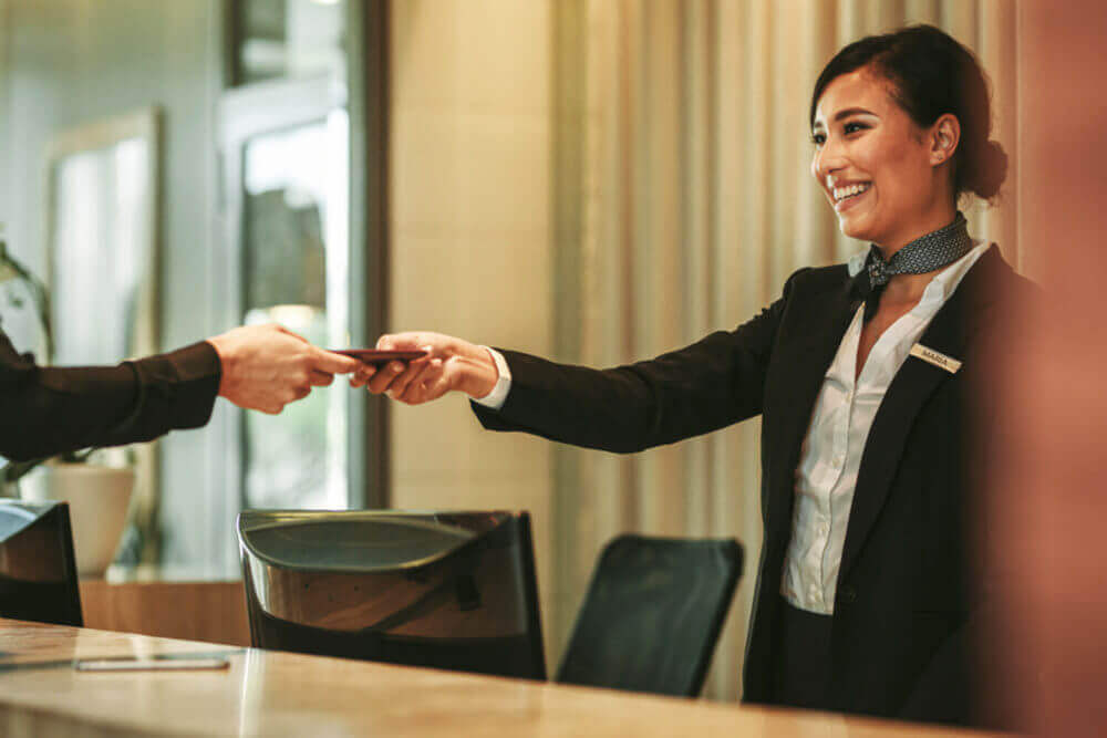 Concierge giving the documents to hotel guest = shutterstock