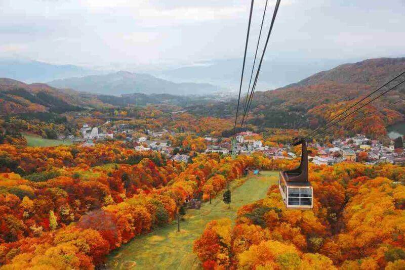 Aerial view of a scenic cable car flying over the beautiful autumn valley of Zao, a popular resort for Onsen and skiing in Yamagata, Japan = shutterstock
