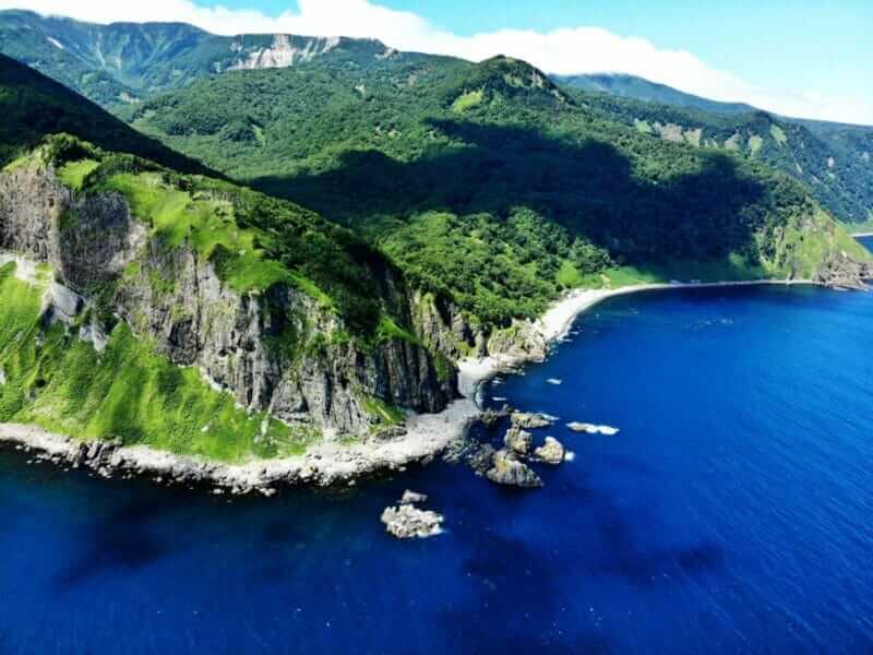 Shiretoko peninsula where rough cliffs continue. You can also see from the sea by a pleasure boat, Hokkaido, Japan = shutterstock