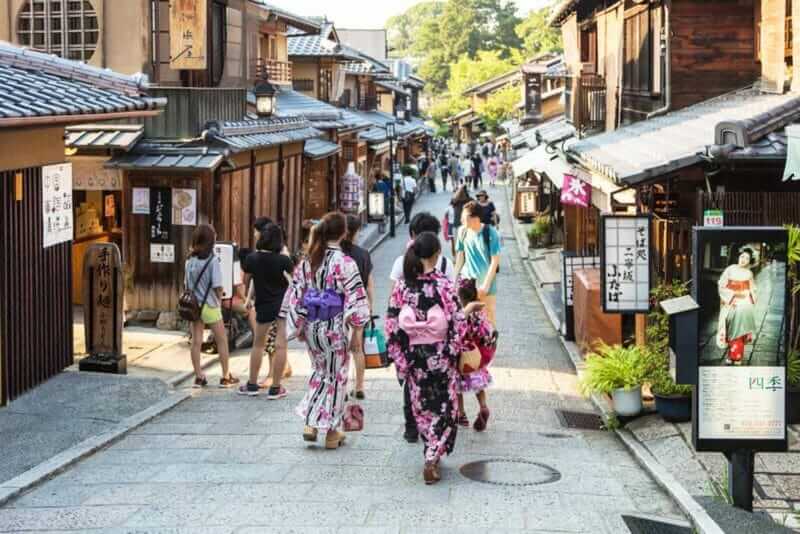 Young women wearing traditional Japanese Kimono walk in the street of Gion, Kyoto old town in Japan = shutterstock