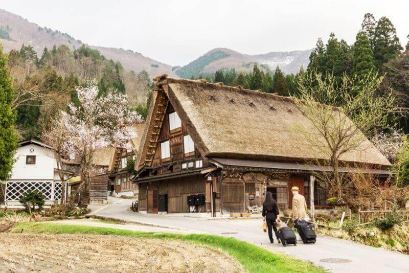 Romantic tourists couple stay overnight at a gassho-zukuri farmhouse Homestay, minshuku, family run, Japanese style lodgings, Shirakawago Village, Gifu, Japan = shutterstock
