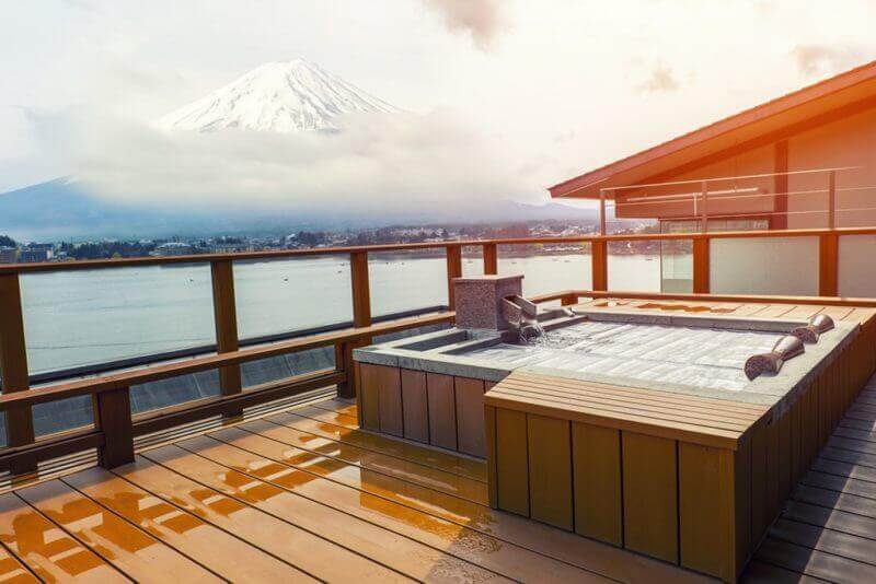 Japanese open air hot spa onsen with view of the mountain Fuji = shutterstock