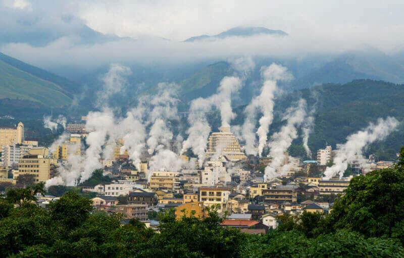 Beautiful scenery of Beppu cityscape with Steam drifted from public baths and ryokan onsen. Beppu is one of the most famous hot spring resorts in Japan, Oita, Kyushu, Japan = shutterstock