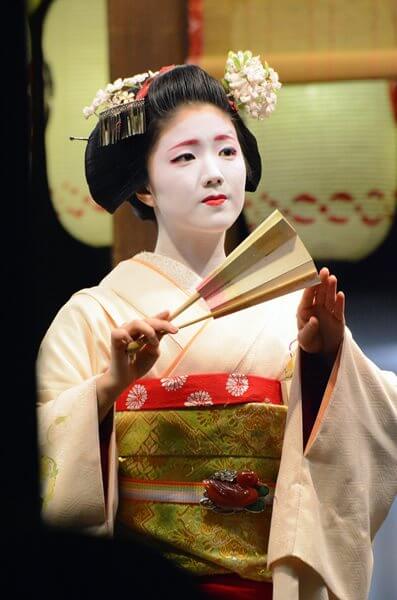 A Japanese geisha performs for Gion Festival at a shrine in Kyoto = shutterstock