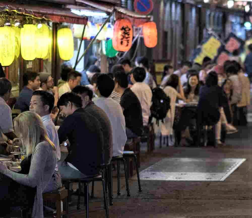 SEPTEMBER 15TH, 2018. Customers enjoying their food at various small eateries or locally known as izakaya at Yurakucho district back alley at night, Tokyo = Shutterstock