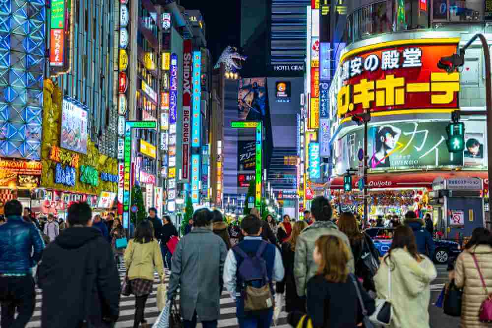December 24, 2018: Crowd pedestrians people walking on crosswalk at Shinjuku district at night in Tokyo, Japan