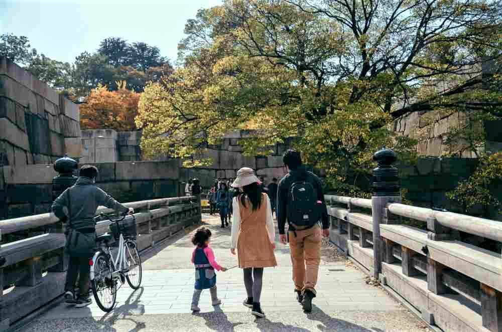 November 4, 2017 - Tourist across the Bridge to Osaka Castle during autumn = Shutterstock
