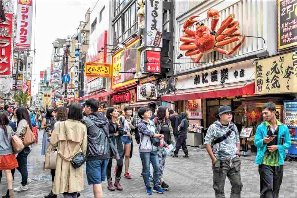 October 15, 2018: Tourists at Dotonbori in Osaka, which is a popular destination for shopping and sightseeing. Osaka, Japan = Shutterstock