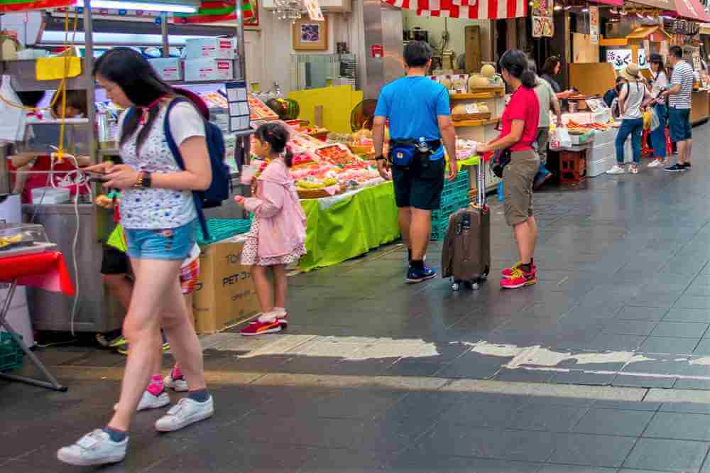 JULY 18, 2017: Unidentified people walking at the market of Osaka shopping and visit seafood prices in shop in Osaka, Japan = Shutterstock