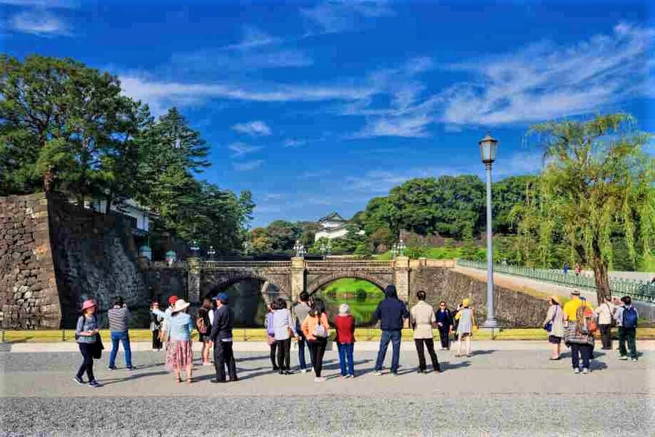 NOVEMBER 4: Tourists visit the Tokyo Imperial Palace Outer Gardens with the famous Nijubashi Bridge, Tokyo, Japan = Shutterstock