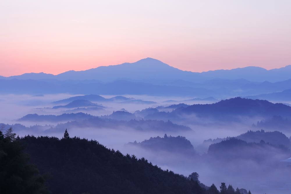 Blue mountains silhouettes in sunrise. Foggy blue dreamy landscape. Ouda, Nara, japan = Shutterstock