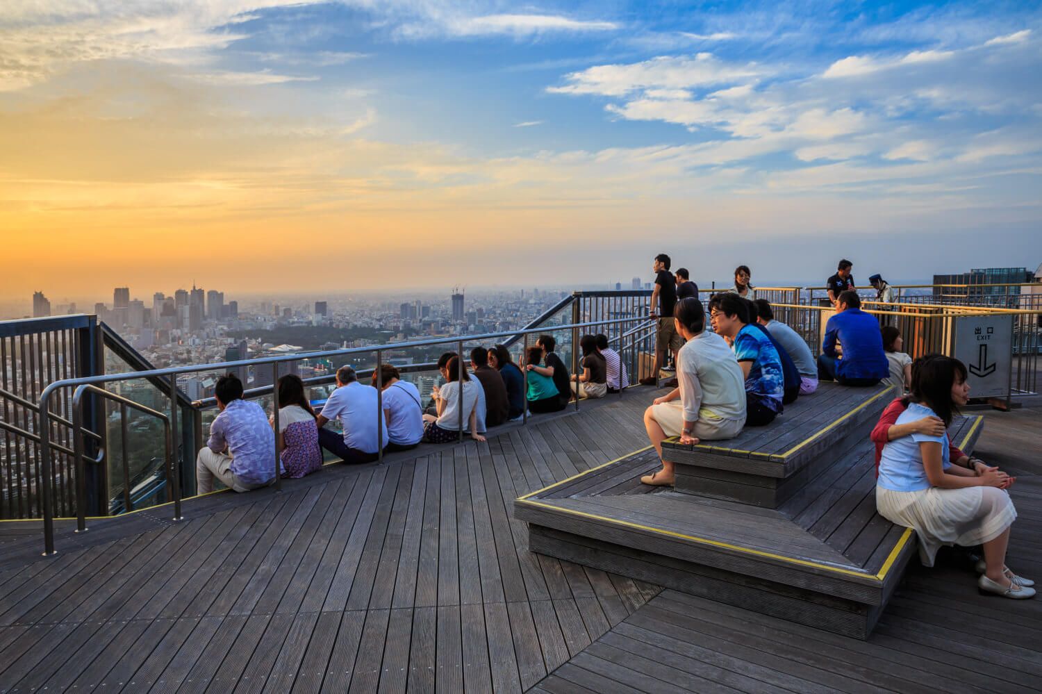 Tourists enjoy sunset at Roppongi Hills Mori Tower. It's the centerpiece of the Roppongi Hills urban development, currently the fifth-tallest building in Tokyo = Shutterstock