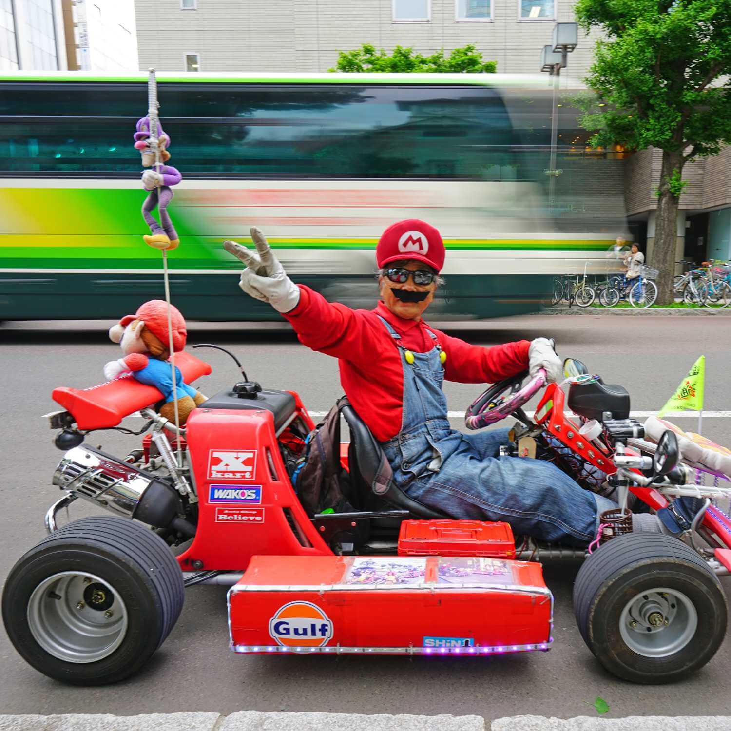  A man and his car costumed as Luigi and Mario Kart on the street in Sapporo = Shutterstock