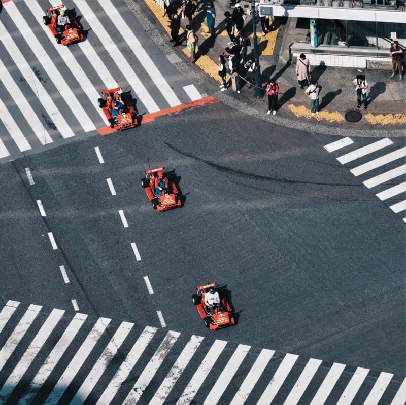 A tourist drives a Maricar rental go-cart through shibuya junction in central Tokyo = Shutterstock