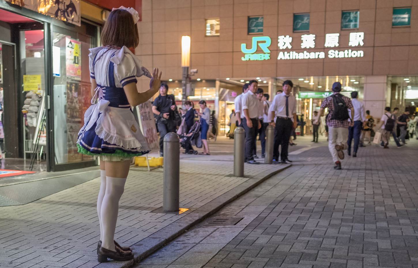 Japanese in maid dress trying to entice customers into maid cafe in Akihabara=Shutterstock