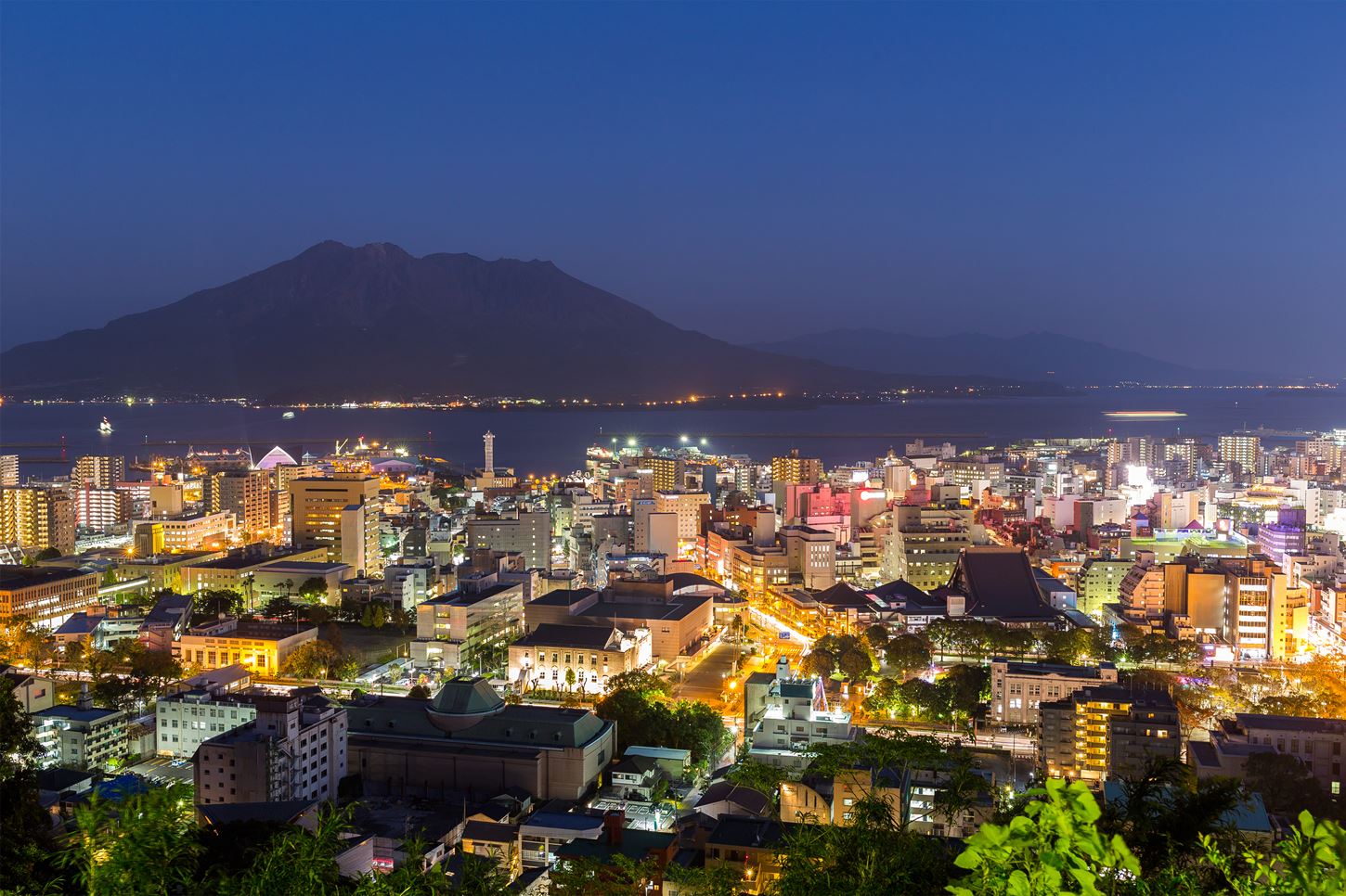 From Kagoshima City's Shiroyama, you can see a beautiful night view of Kagoshima City and the powerful Sakurajima Island = Shutterstock